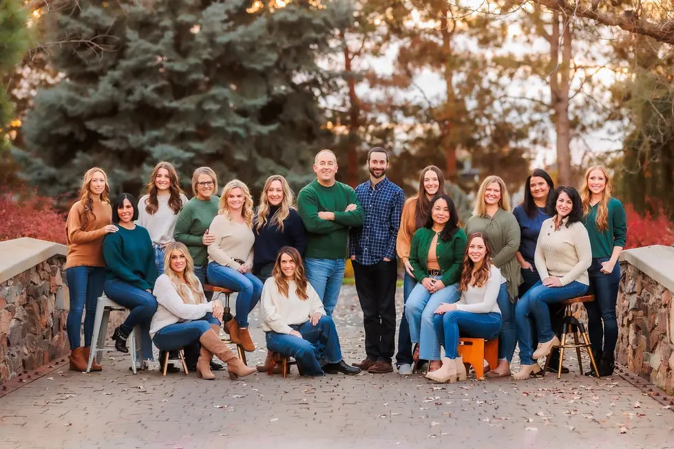 The Copperstone Dental team outdoors on a stone bridge in autumn