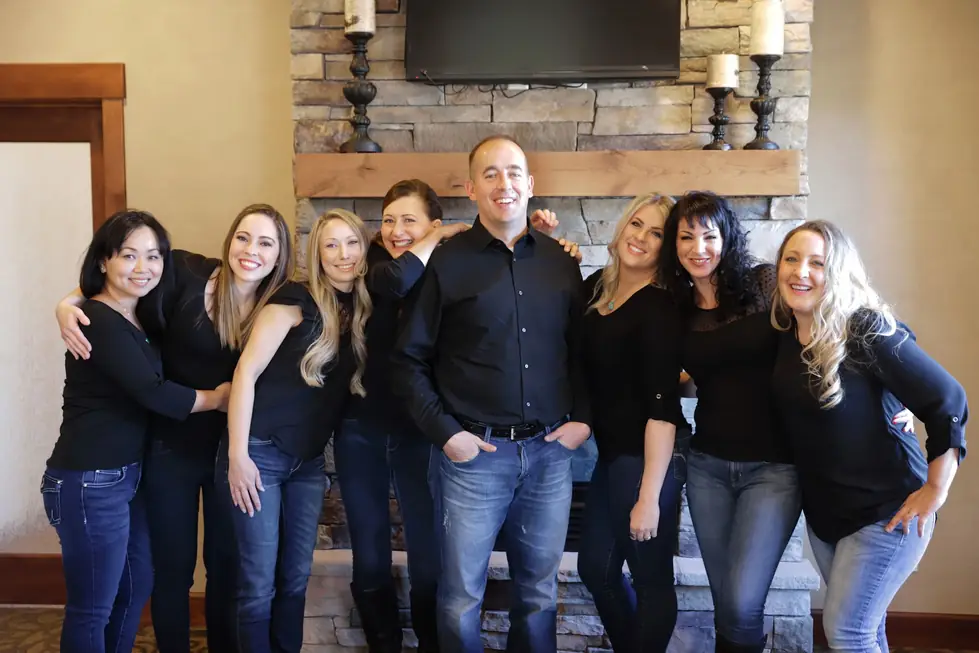 The Copperstone Dental team indoors by a stone fireplace