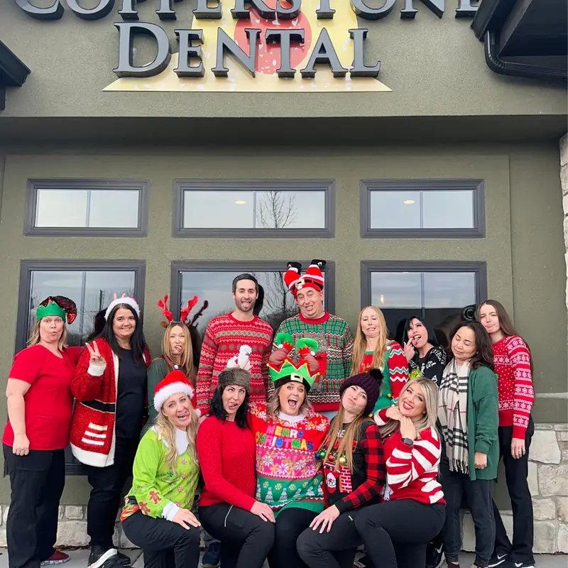 The Copperstone Dental team in holiday sweaters outside the practice